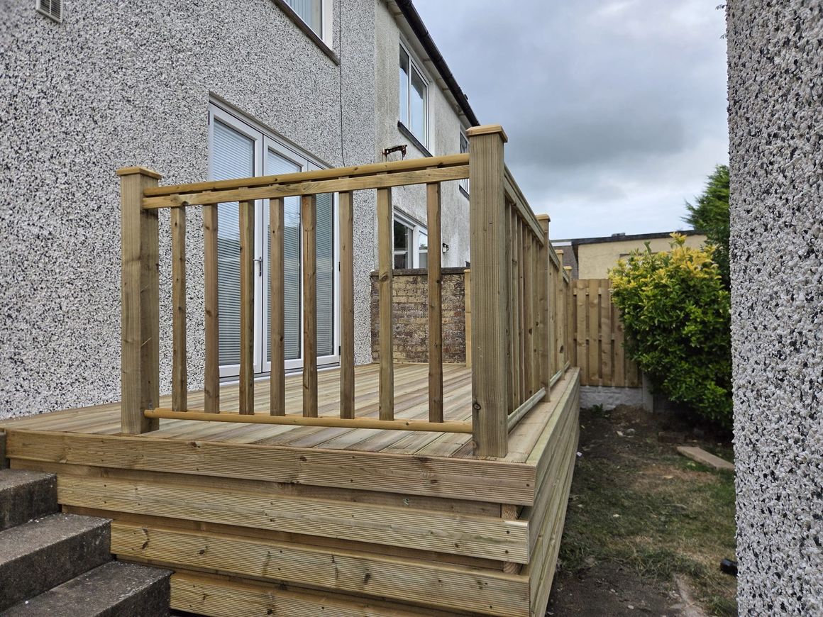 Raised timber deck with a spindle balustrade and steps down to the garden